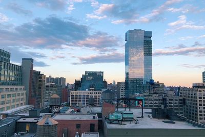 Modern buildings in city against sky during sunset