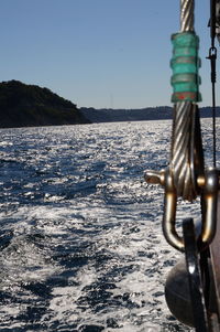 Close-up of sailboat in sea against clear sky