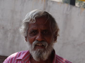 Portrait of senior man against wall