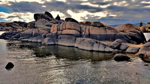 Rock formations by sea against sky