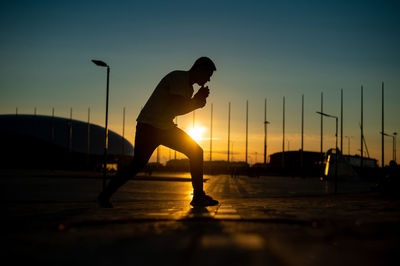 Low angle view of silhouette man walking on street