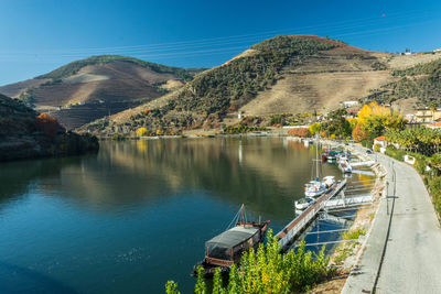 Scenic view of lake and mountains against clear blue sky