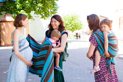 Rear view of women standing against people