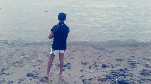 Rear view of man standing on beach