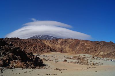 Scenic view of mountains against blue sky