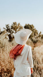 Rear view of woman standing by plants in farm