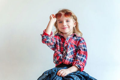 Portrait of young woman standing against wall