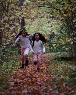 Full length of mother with daughter in forest