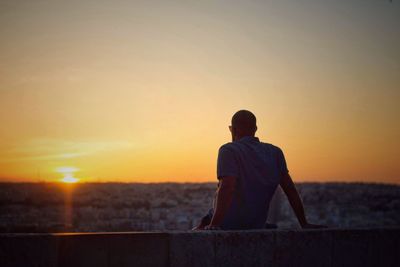 Rear view of man looking at sunset