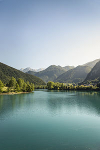 Scenic view of lake and mountains against clear sky