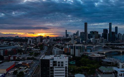 Aerial view of modern buildings in city against sky during sunset