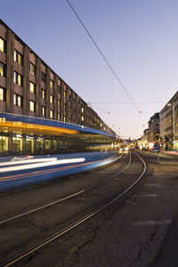 Moving tram on street in city at dusk