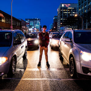 Man standing on road in city at night