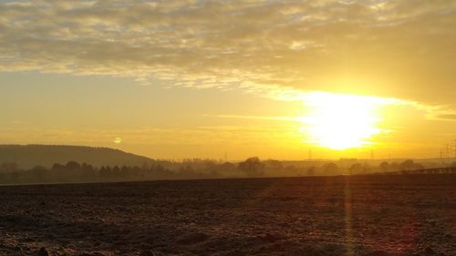 Scenic view of field against sky during sunset