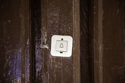 Close-up of doorbell on wooden door