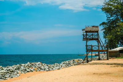 Lifeguard hut on beach against sky