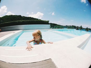 Portrait of boy in swimming pool against sky