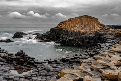 View of rocky beach against clouds