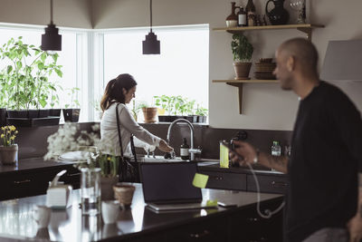 Side view of a man and woman standing at table