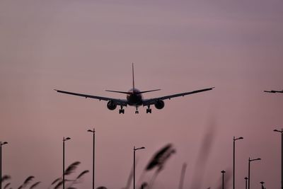 Low angle view of silhouette airplane against clear sky