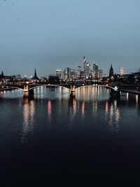 Illuminated buildings in city at waterfront