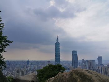 View of cityscape against cloudy sky