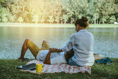 Couple relaxing at lakeshore