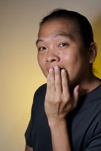 Close-up portrait of mature man against colored background