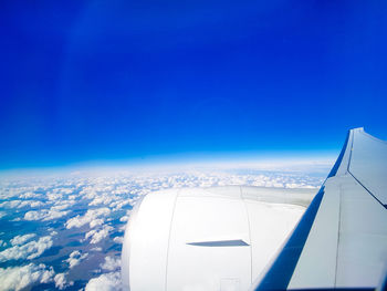 Airplane flying over clouds against blue sky