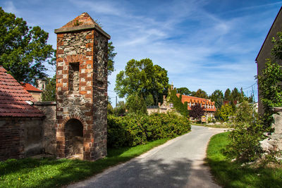 Old ruin amidst buildings against sky