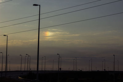 Street lights against sky during sunset