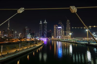 Illuminated buildings by river at night