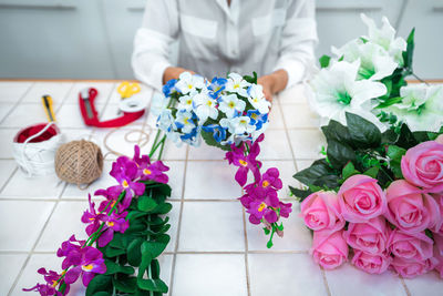 Midsection of bride holding bouquet