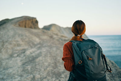 Rear view of woman looking at sea against sky