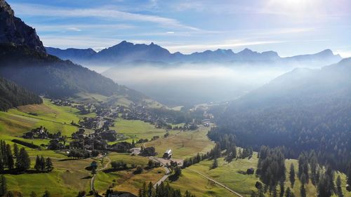 Scenic drone view of mountains against sky with low clouds in the distance