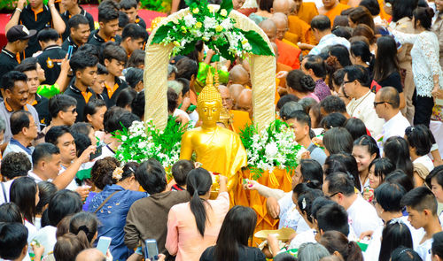 High angle view of golden buddha statue amidst crowd in city