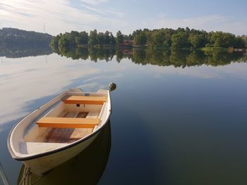 Boat moored on lake against sky