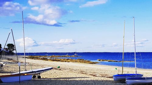 Sailboats moored on sea against sky