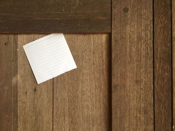 Close-up of paper on wooden wall