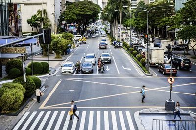 High angle view of people and vehicles on road in city