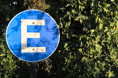 Close-up of information sign reading the letter e for spanish estacionamientos on a praking lot 