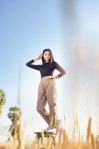 Woman standing on field against sky