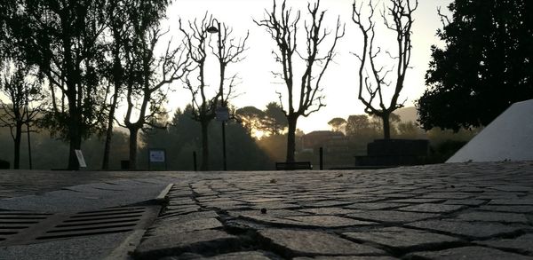 Footpath by street in city against sky