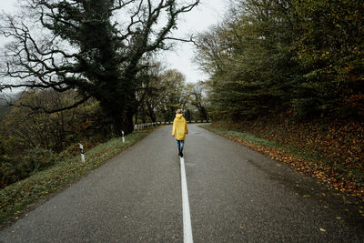 Rear view of man walking on road