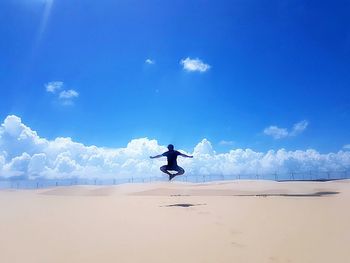 Man surfing on beach against sky