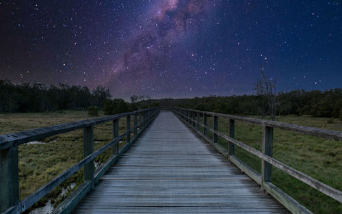 Footbridge against sky at night