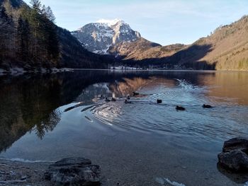 Scenic view of lake by mountains against sky