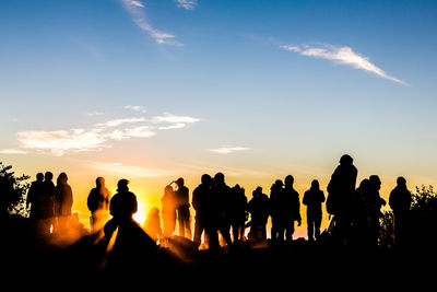 Silhouette people standing against sky during sunset