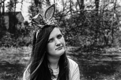 Portrait of beautiful young woman against trees