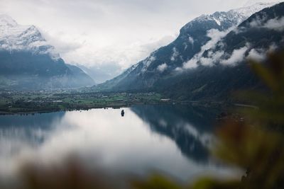 Scenic view of lake by mountains against sky